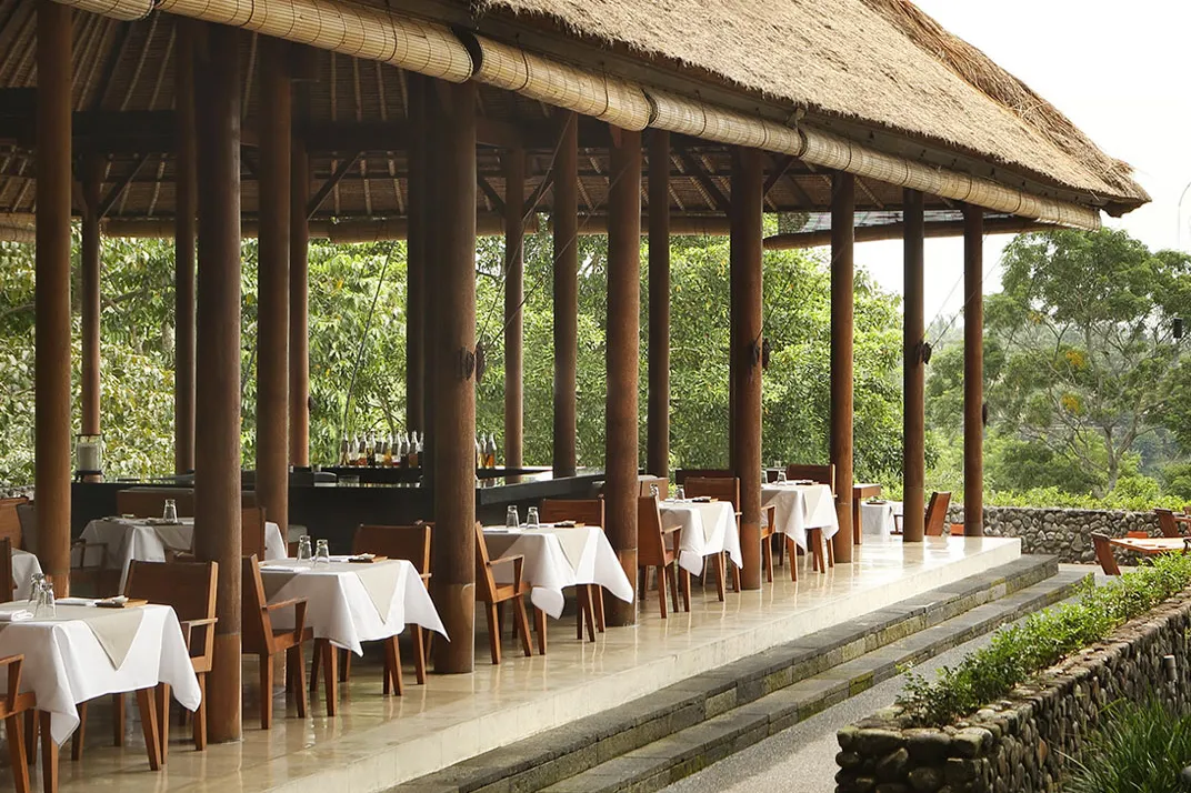 The Plantation restaurant at Alila Ubud, tables set under a deep thatched roof