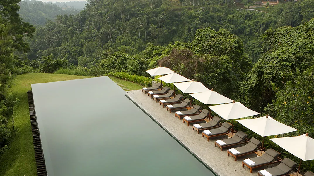 The infinity pool at Alila Ubud from above, stretching towards the jungle of the Ayung valley