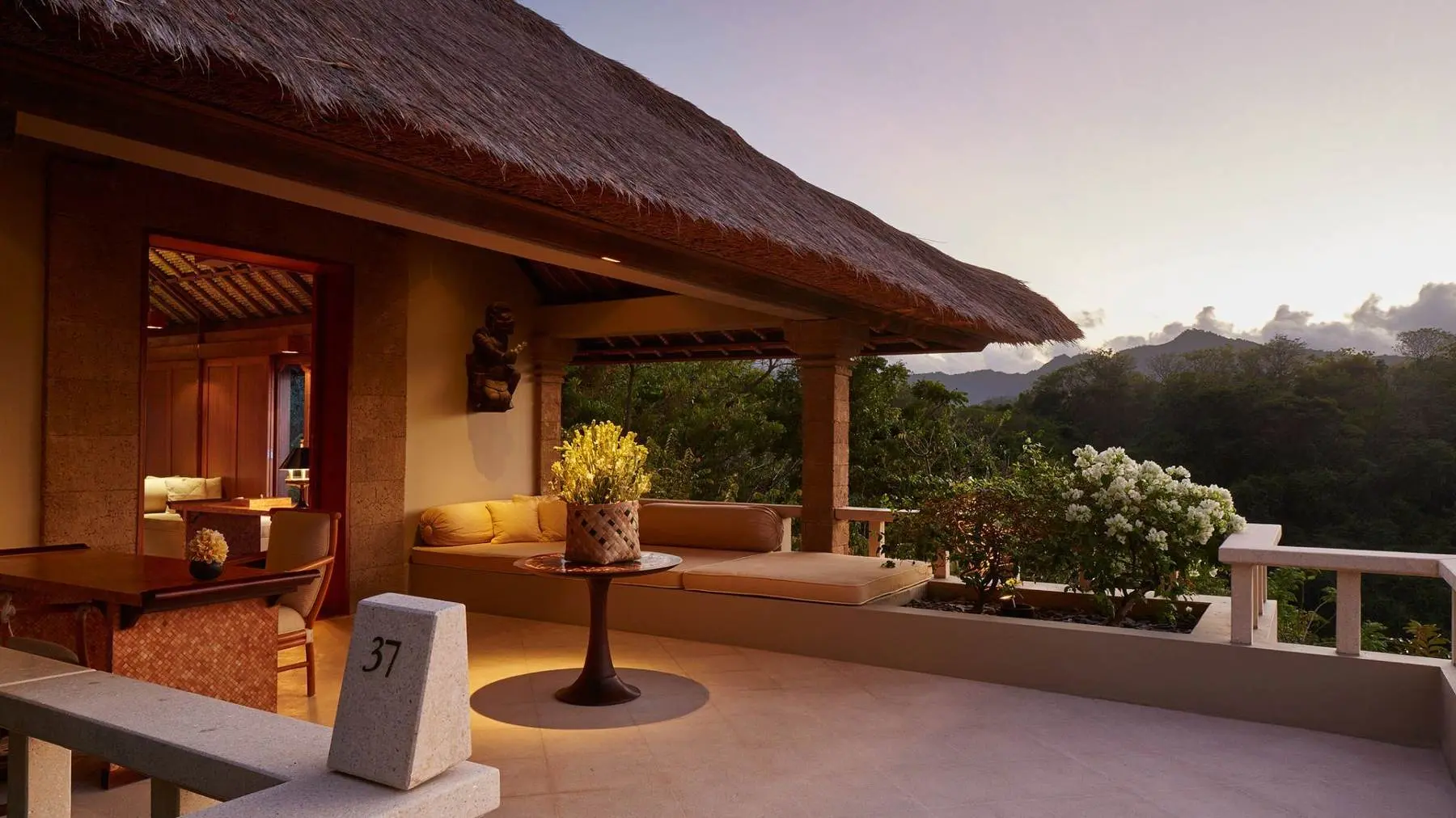 An open suite terrace at Amankila at dusk, looking out over the hills