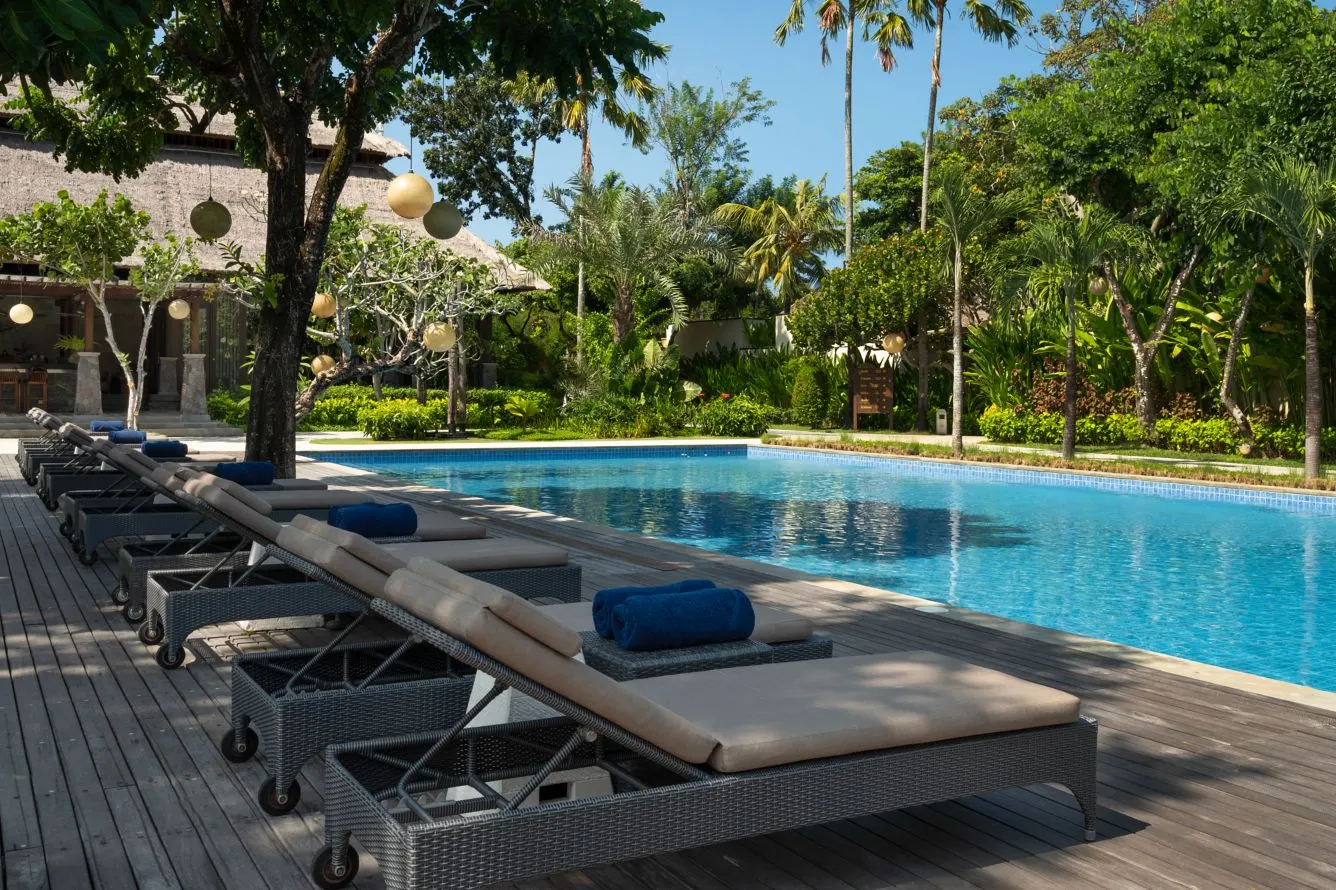 The main pool at Amarterra, loungers in the shade of old trees hung with paper lanterns