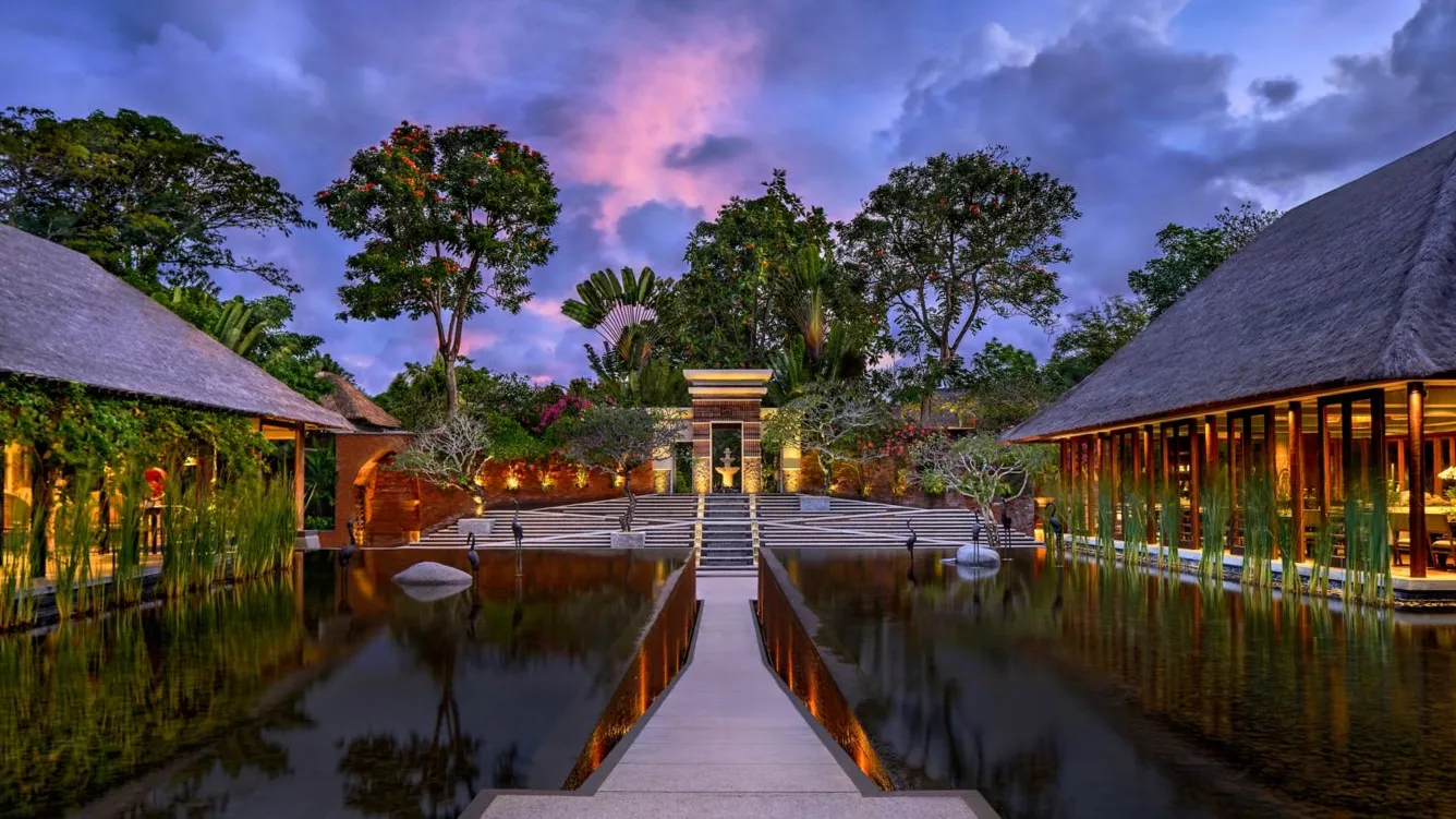 The water court at Amarterra at dusk, a path between two reflecting pools leading to a red-brick gate