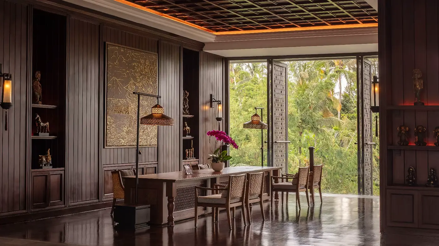 A wood-panelled interior at Anantara Ubud, with Balinese artefacts and a view onto the forest