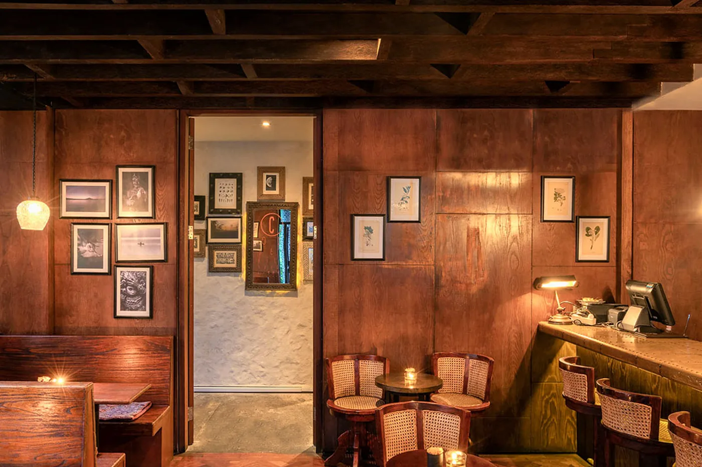 The panelled bar at Bisma Eight, wood, herringbone floor and low lamplight