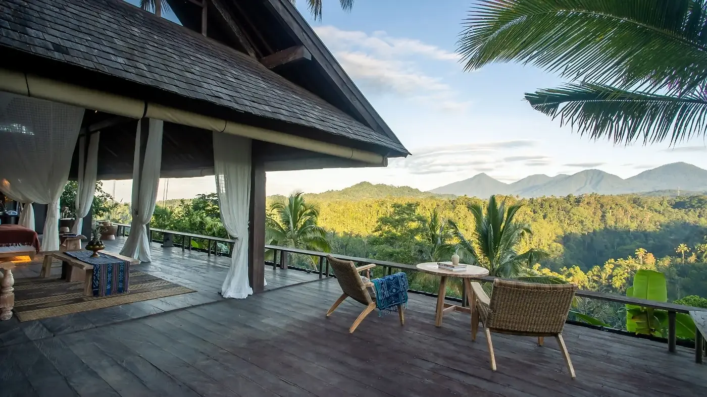 A balé terrace at Buahan, rattan chairs and open curtains looking out over the Ayung valley