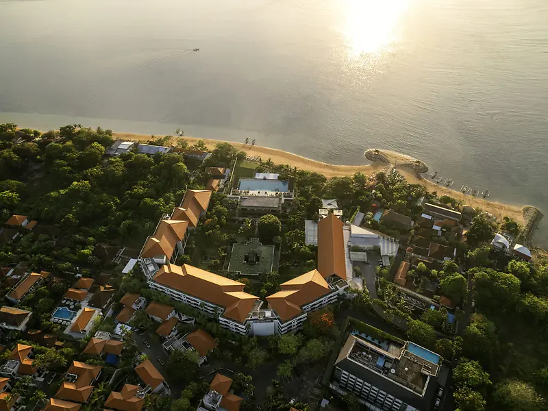 Aerial view of InterContinental Bali Sanur, its orange tiled roofs and single main pool set among dense gardens by the beach