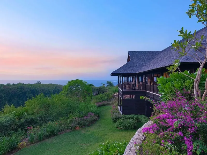 The Raffles Bali's main pavilion at dusk, perched above the valley overlooking the Indian Ocean
