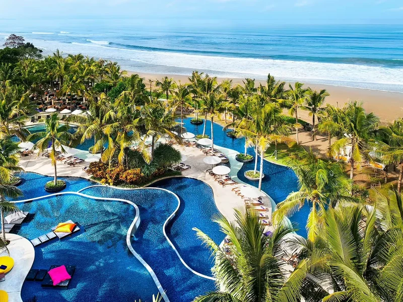 The winding pool at W Bali, Seminyak, palm trees leading down to the beach