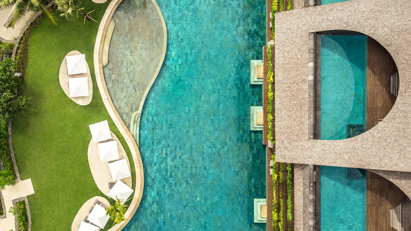 Aerial view of the 115-metre lagoon pool at COMO Uma Canggu, running alongside the ground-floor residences