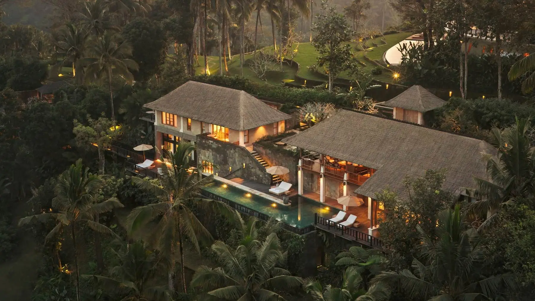 Aerial view of a Residence at Como Shambhala Estate at dusk, lit up amid the jungle