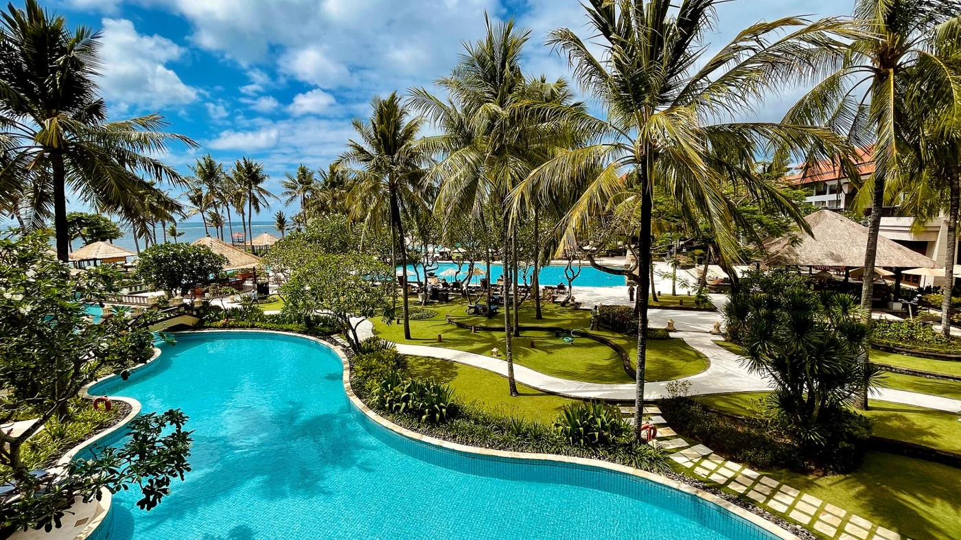View from a balcony over the pool and gardens at Conrad Bali