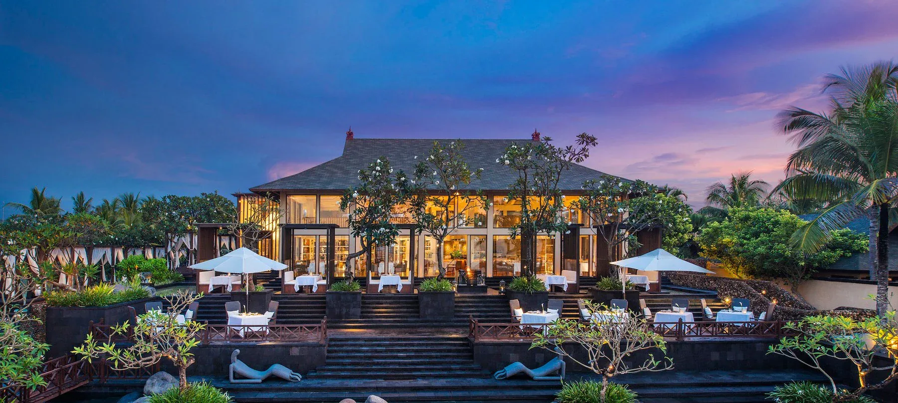 Kayuputi at The St. Regis Bali at dusk, terraces set out in front of the pavilion