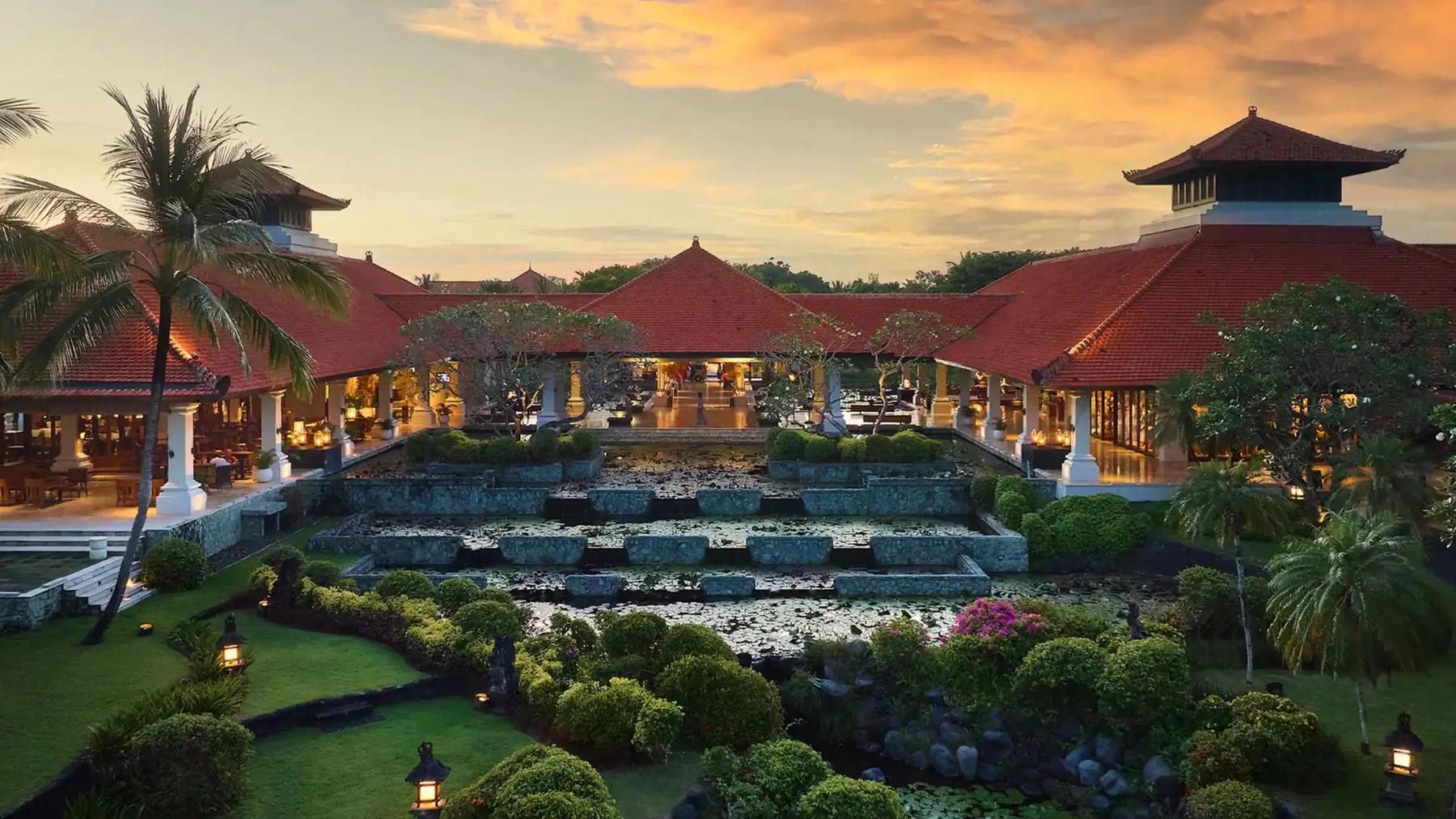 The lobby at Grand Hyatt Bali at dusk, with lily ponds stepping down towards the sea