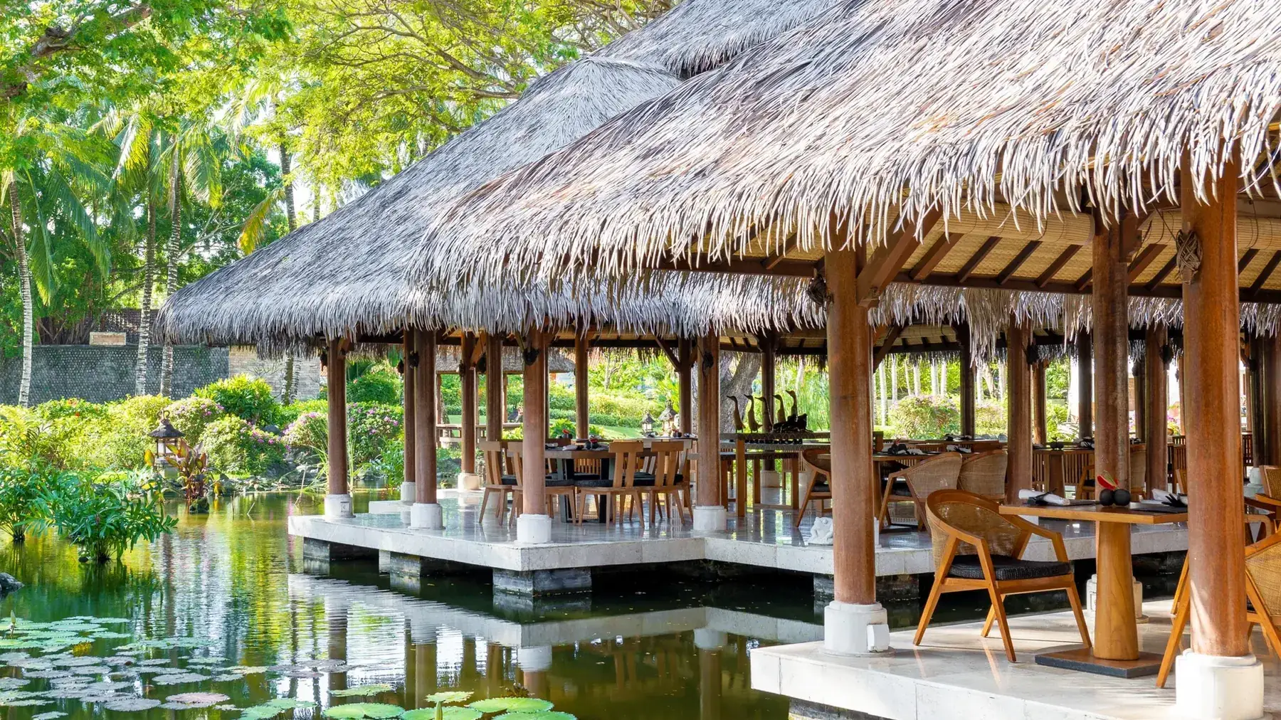 A thatched dining pavilion standing over the lily ponds at Grand Hyatt Bali