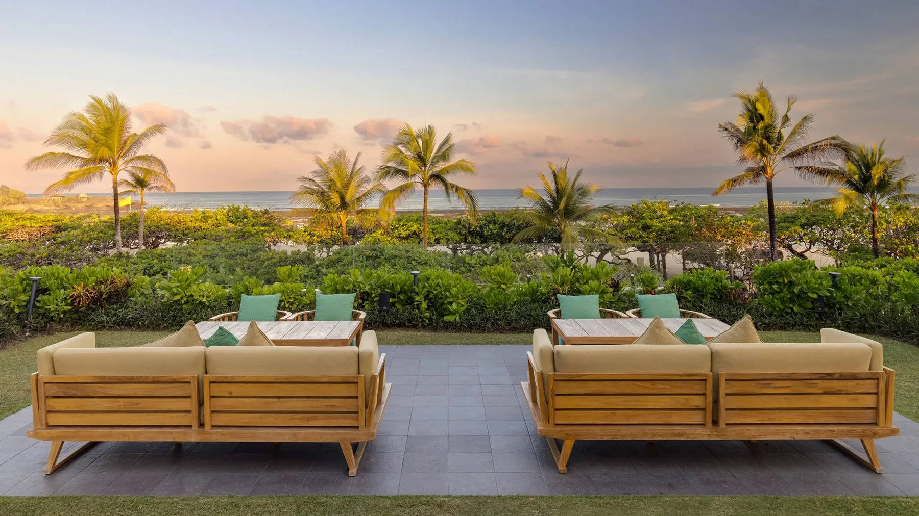 Sofas facing the sea at sunset in the gardens of Grand Hyatt Bali
