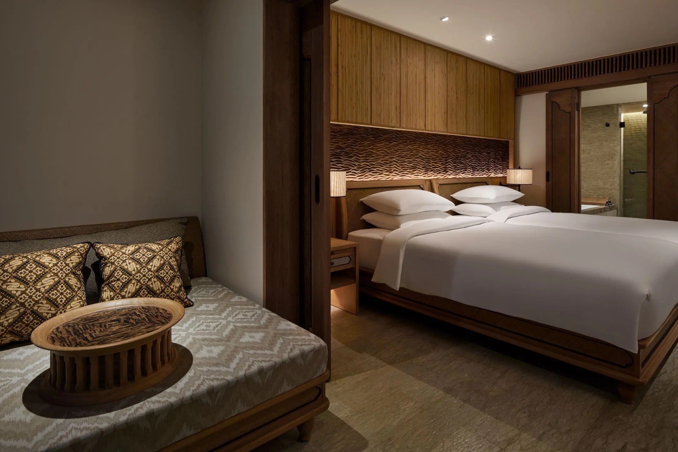 A guest room at Hyatt Regency Bali, with wooden furniture and Balinese carving