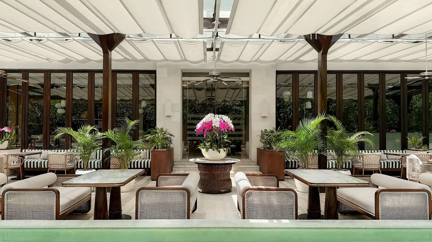 A poolside lounge terrace at InterContinental Bali Sanur, with orchids and striped banquette seating