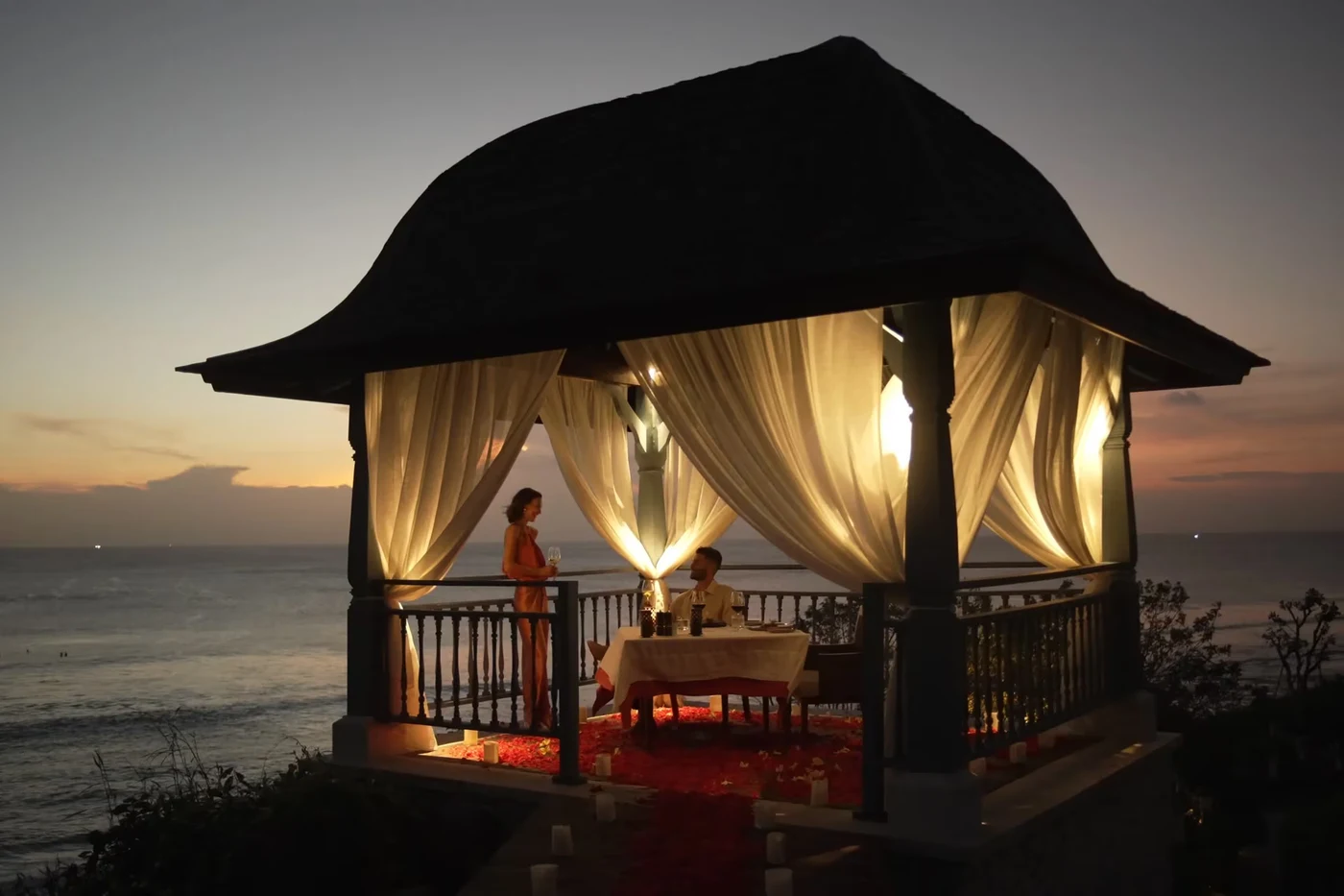 A private dinner pavilion at Jumeirah Bali at dusk, set for two above the ocean