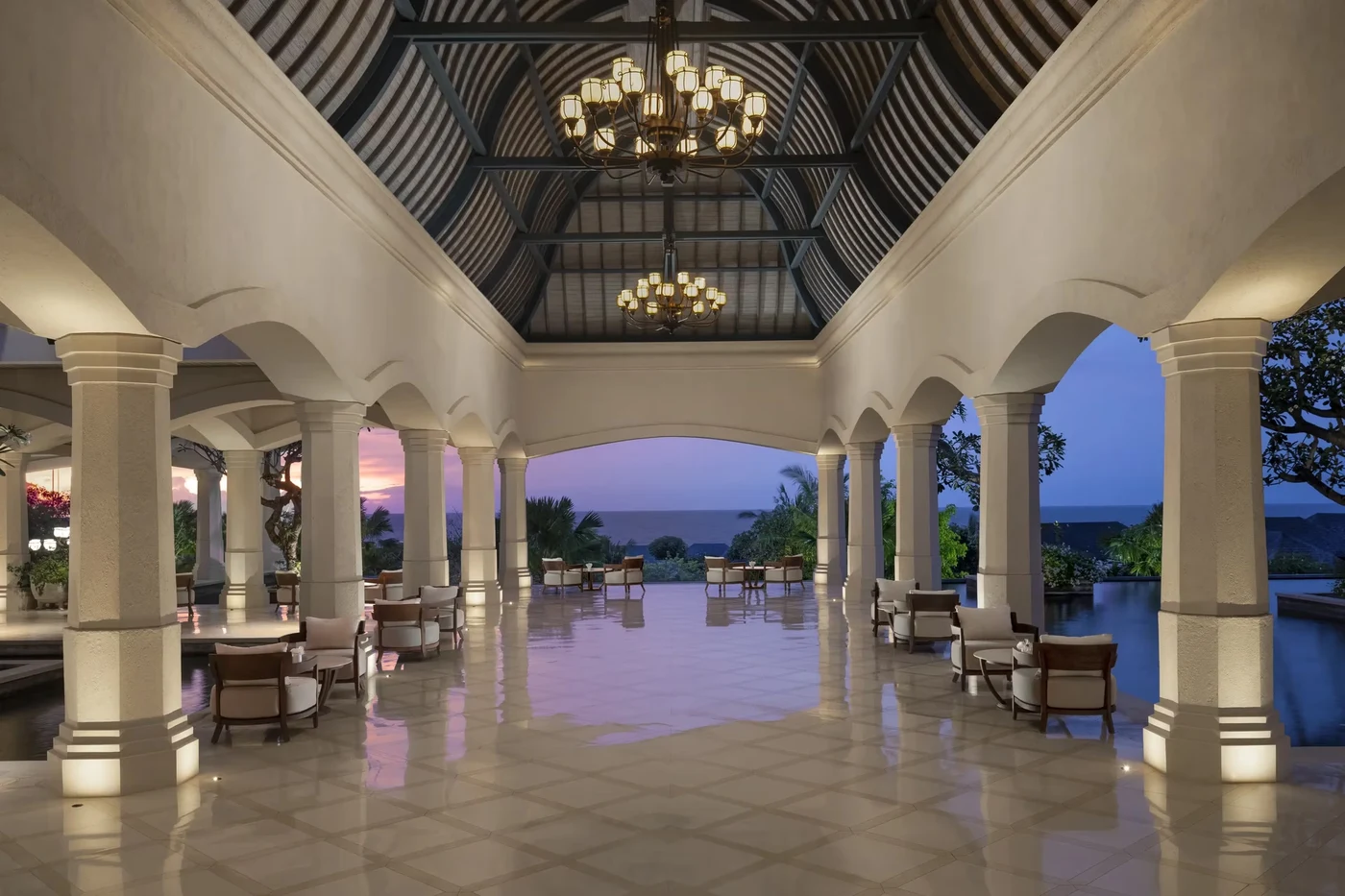 The colonnaded arrival pavilion at Jumeirah Bali at dusk, looking out towards the ocean