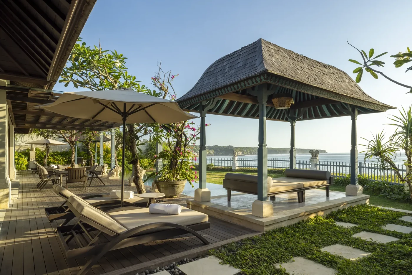 A villa's outdoor pendopo pavilion and loungers at Jumeirah Bali, overlooking the ocean