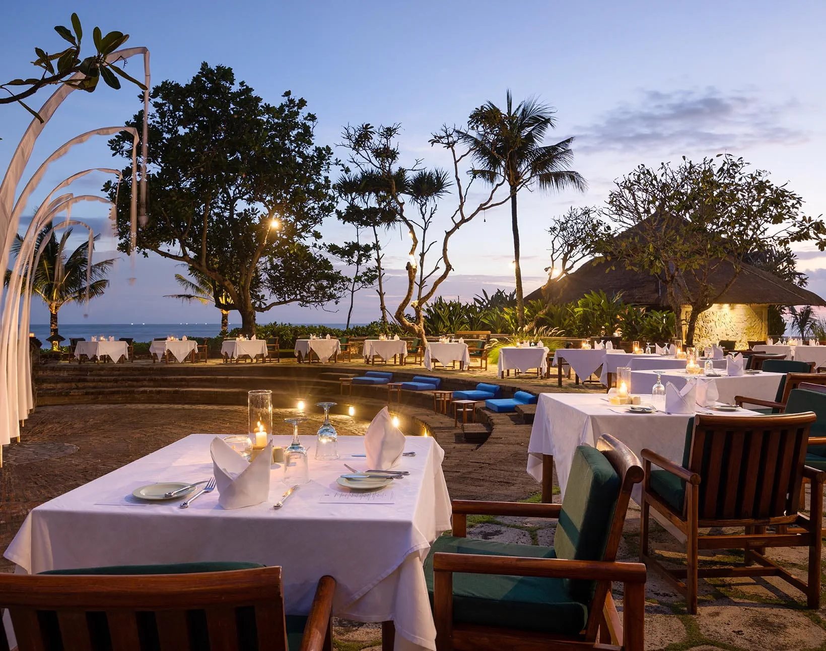 The amphitheatre at The Oberoi Bali set for dinner at dusk, overlooking the ocean