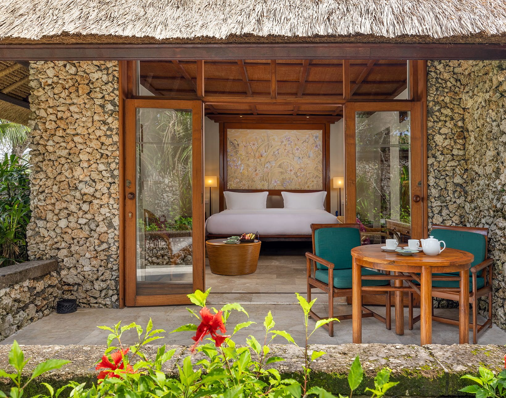 Coral stone villa terrace at The Oberoi Bali, opening onto the tropical garden