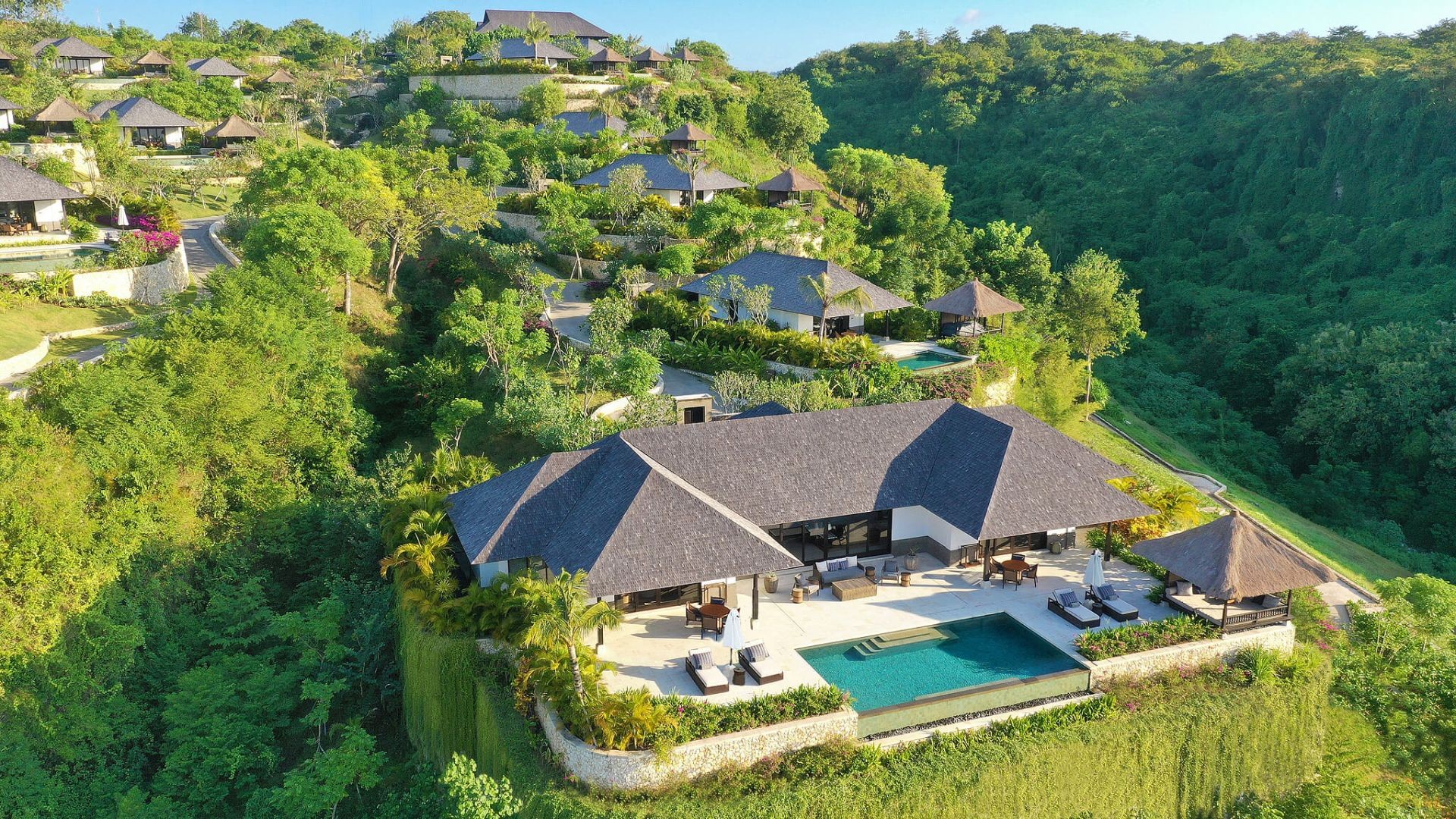 An aerial view of a single villa at The Raffles Bali, perched above the jungle on the cliff edge