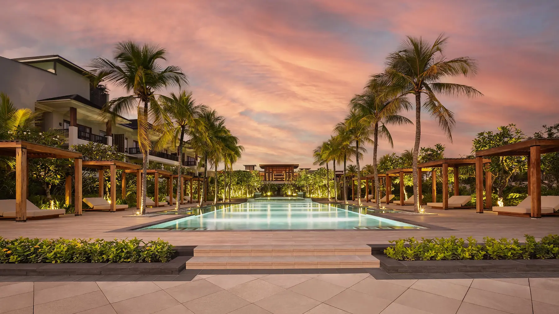 The colonnade and pool at Regent Bali Canggu at dusk