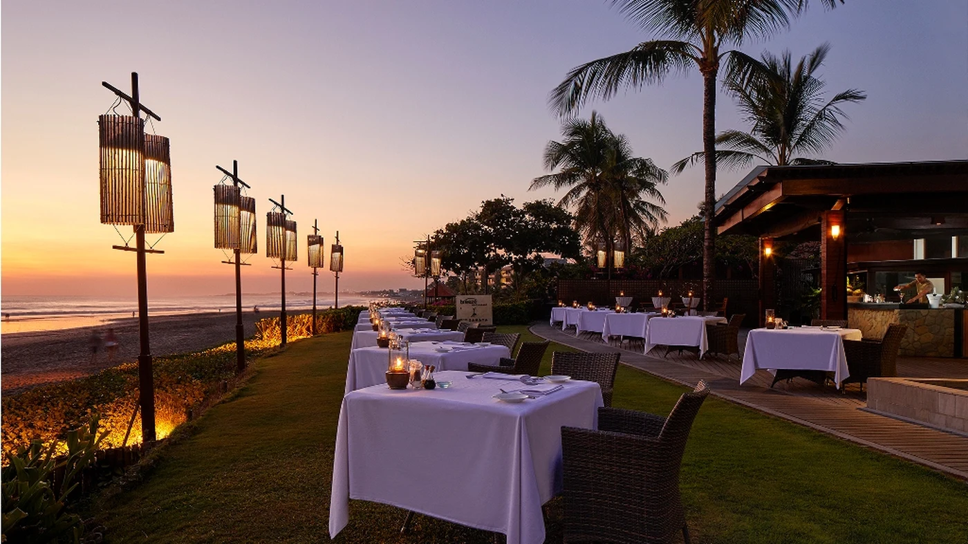 Dinner tables set along the beach at dusk, The Samaya Seminyak