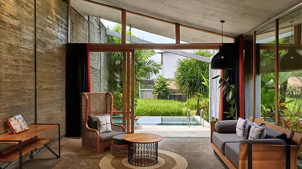 A villa living room at Shore Amora, opening onto a private plunge pool and rice field view