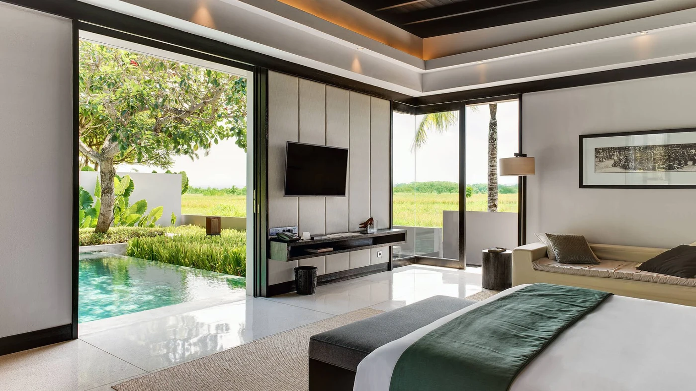 A villa bedroom at Soori Bali opening onto its private pool and the rice fields beyond