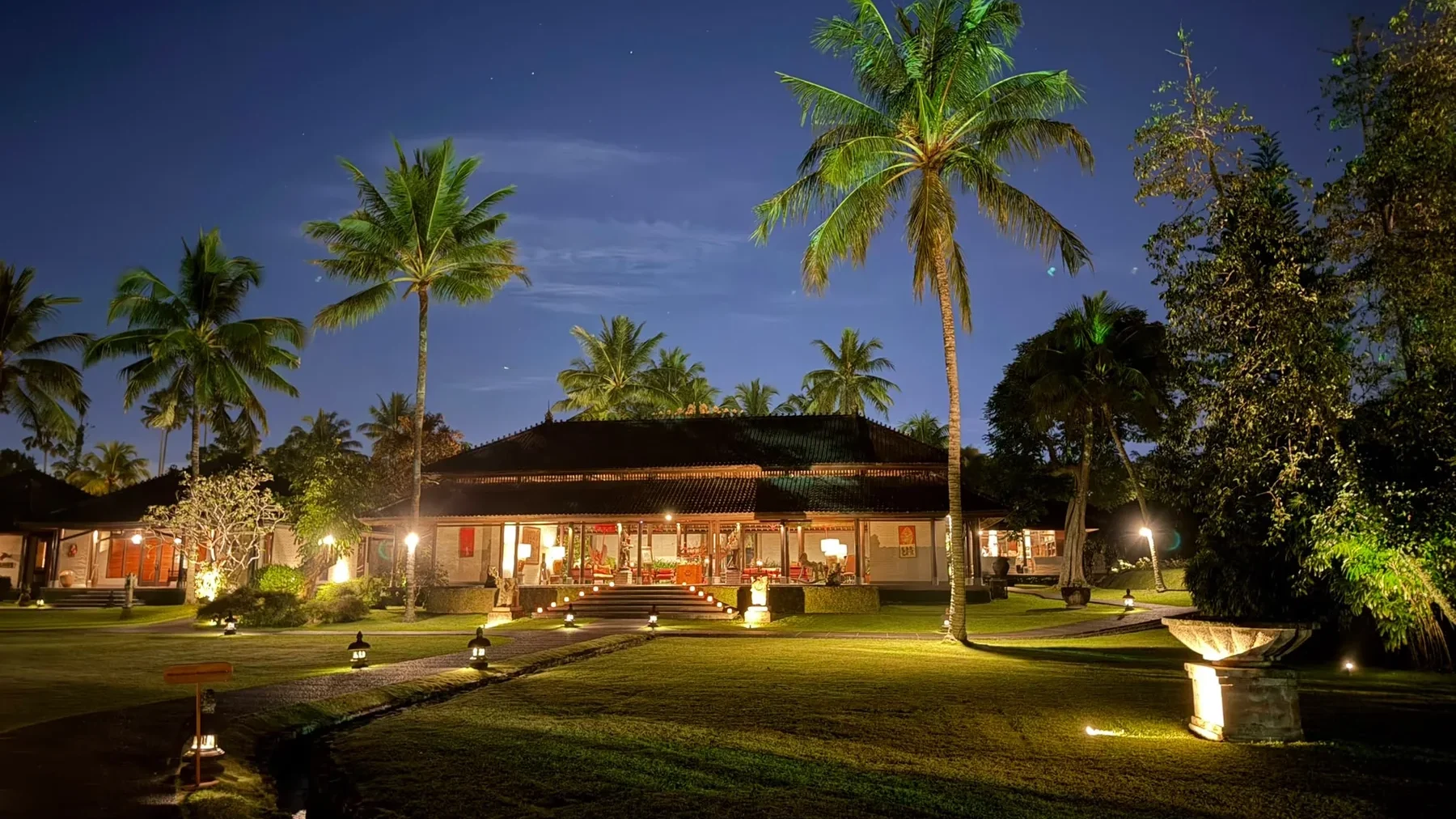 Tanah Gajah at night, its lawns and pavilions lit beneath the palms