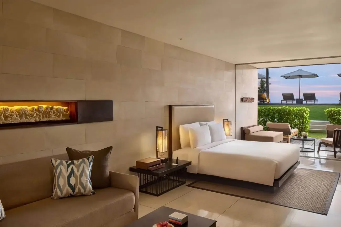 A guest room at Alila Seminyak, with a custom carved relief panel and a private terrace