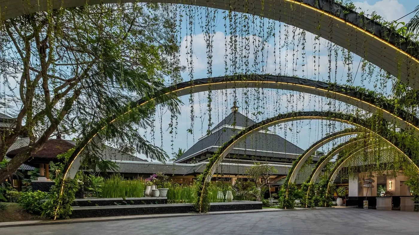 Arched walkway with hanging vines leading to the main pavilion at InterContinental Bali Resort