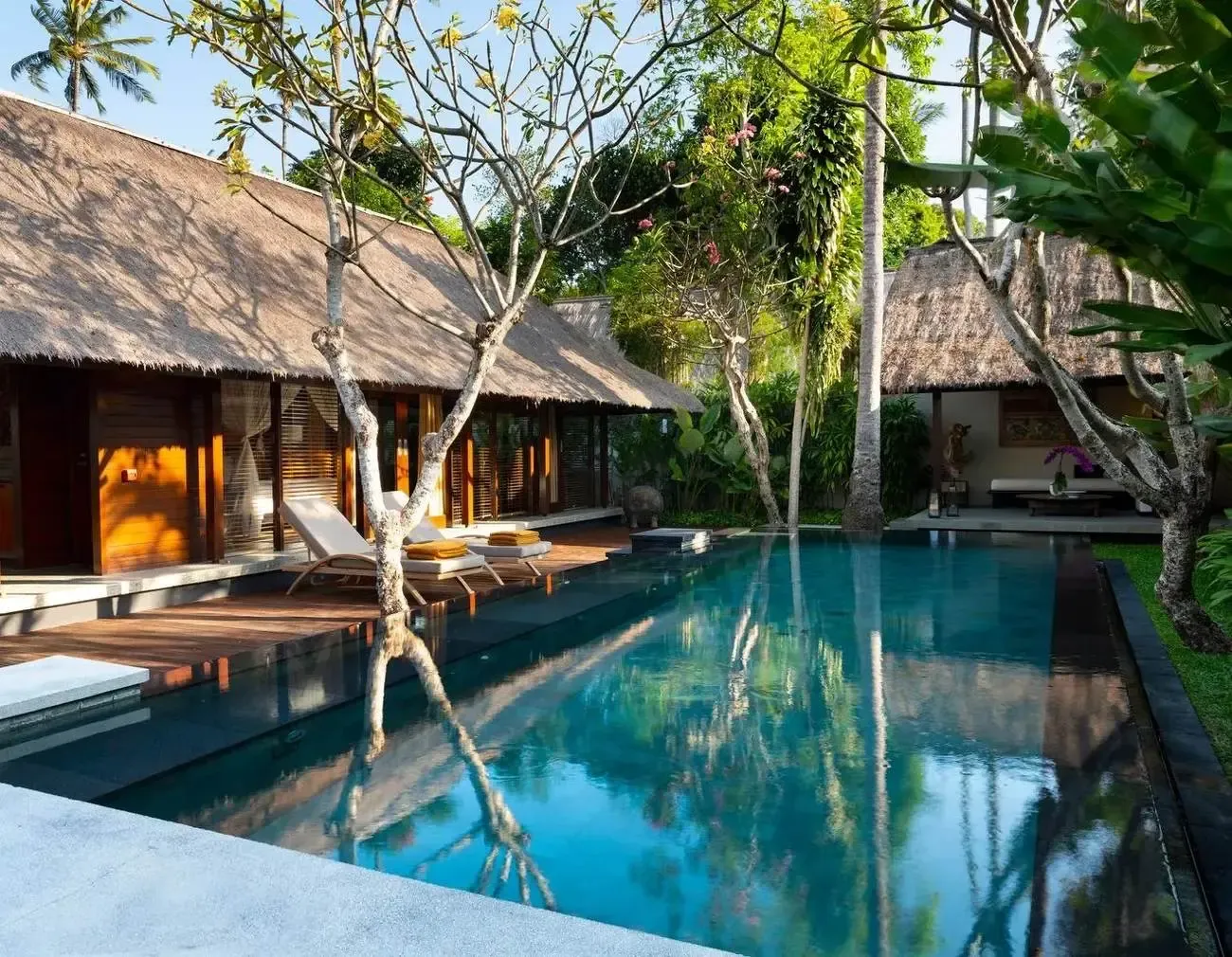 A private pool villa at Kayumanis Jimbaran, framed by thatched roofs and coconut palms