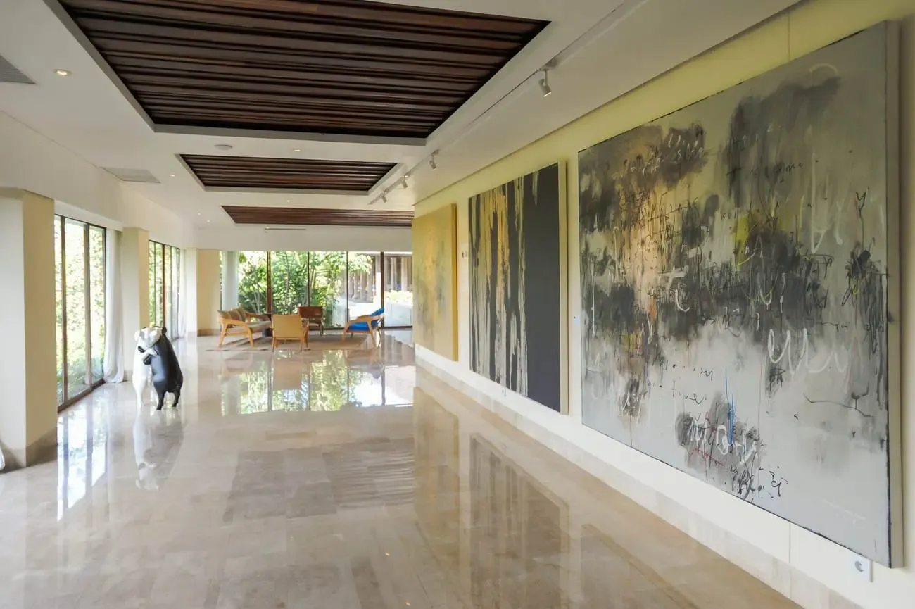 Gallery hallway at Komaneka at Keramas Beach lined with large contemporary Indonesian paintings