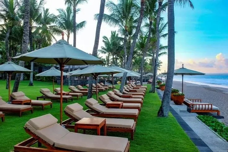 Sunbeds on the lawn leading straight onto the beach at The Legian, Seminyak, at sunrise
