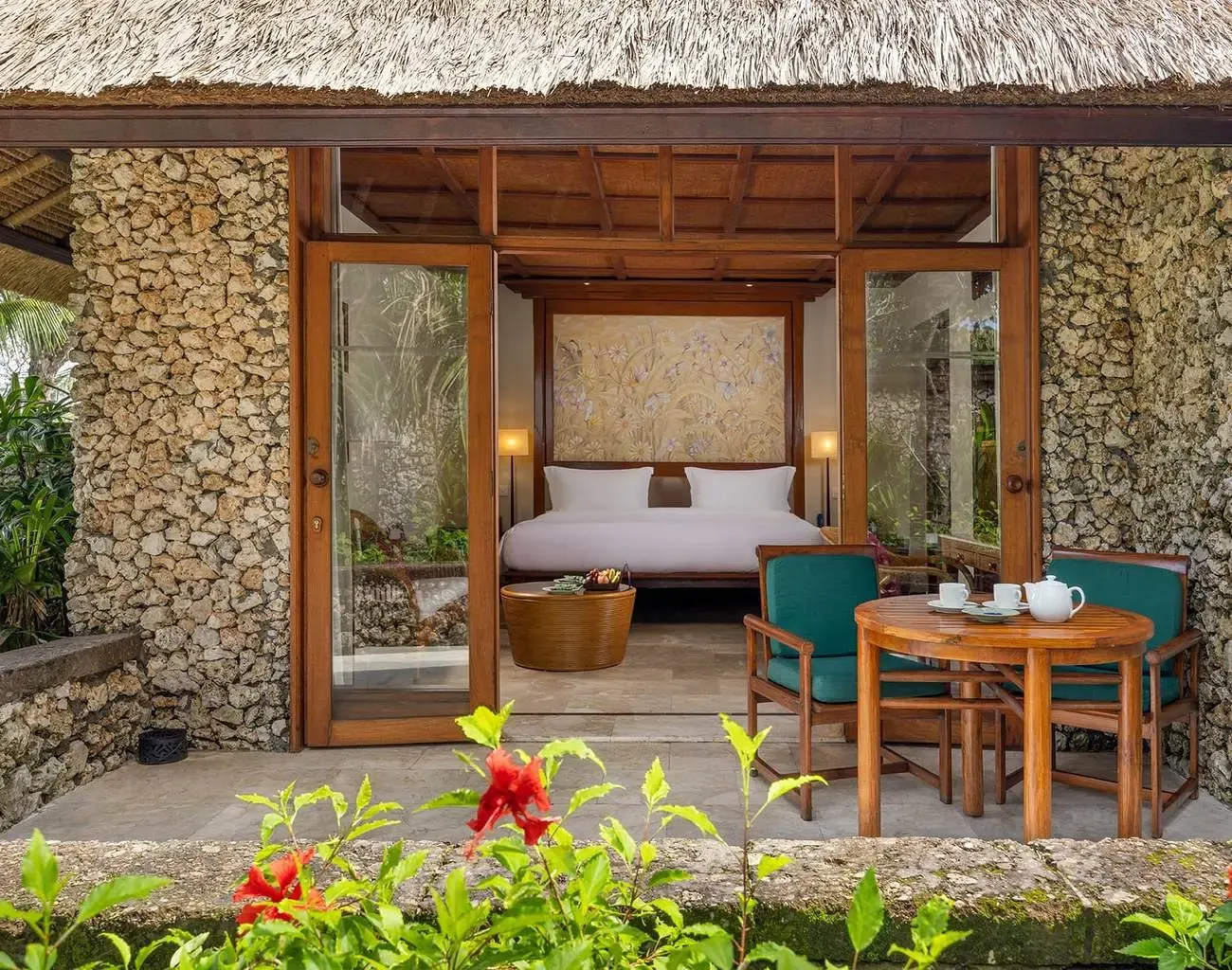Coral stone villa terrace at The Oberoi Bali, opening onto the tropical garden