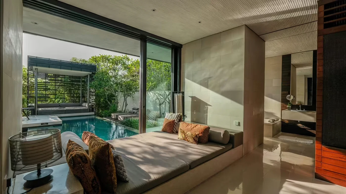 A villa bedroom at Alila Villas Uluwatu opening onto its private pool and walled garden, no sea view